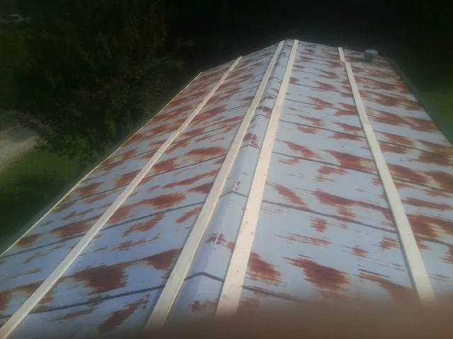 Rusted metal roof panels with new wood purlins before replacement — Storm Damage Roof Repair in Penrose by Roofing Brothers